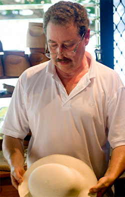 B. Brent Black examines a hat.